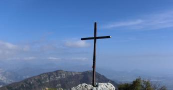 La croce di vetta del Monte Fara. Sullo sfondo, la cresta del Monte Jouf