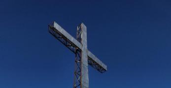 La croce di vetta del Monte Sperone. Sullo sfondo, i Monti del Sole