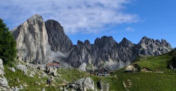 La Sella di Ciampàz Con il Rifugio Roda di Vaèl sulla sinistra e la Baita Marino Pederiva sulla destra. Sullo sfondo, i Mugoni e le Cigolade