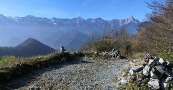 La cima di San Daniele del Monte con il basamento dell’antico sacello. Sullo sfondo, la Catena dell’Alpago